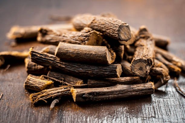 Close up of Ayurvedic herb Liquorice root,Licorice root, Mulethi or Glycyrrhiza glabra root on a wooden surface is very much beneficial for Soothes your stomach,poisoning, stomach ulcers, etc.