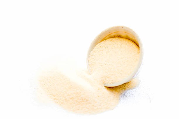Semolina flour in a white colored bowl isolated on white also known as Sooji or Suji.