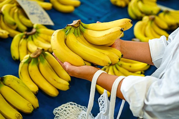young woman buys fresh fruits and vegetables at the market